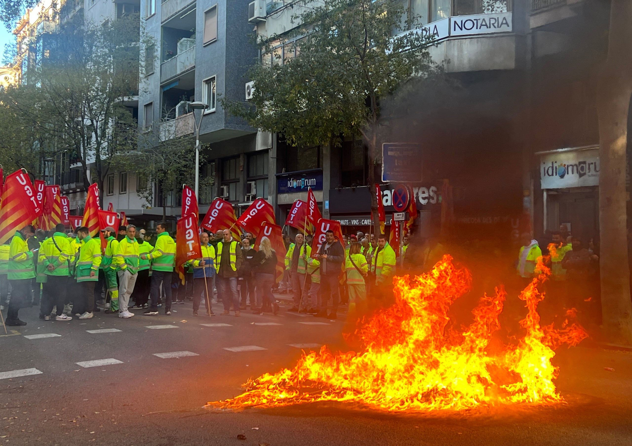 Un contenedor ardiendo en la protesta de los trabajadores de la limpieza de Barcelona frente al departamento de Trabajo en el marco de la mediación | Nazaret Romero (ACN)