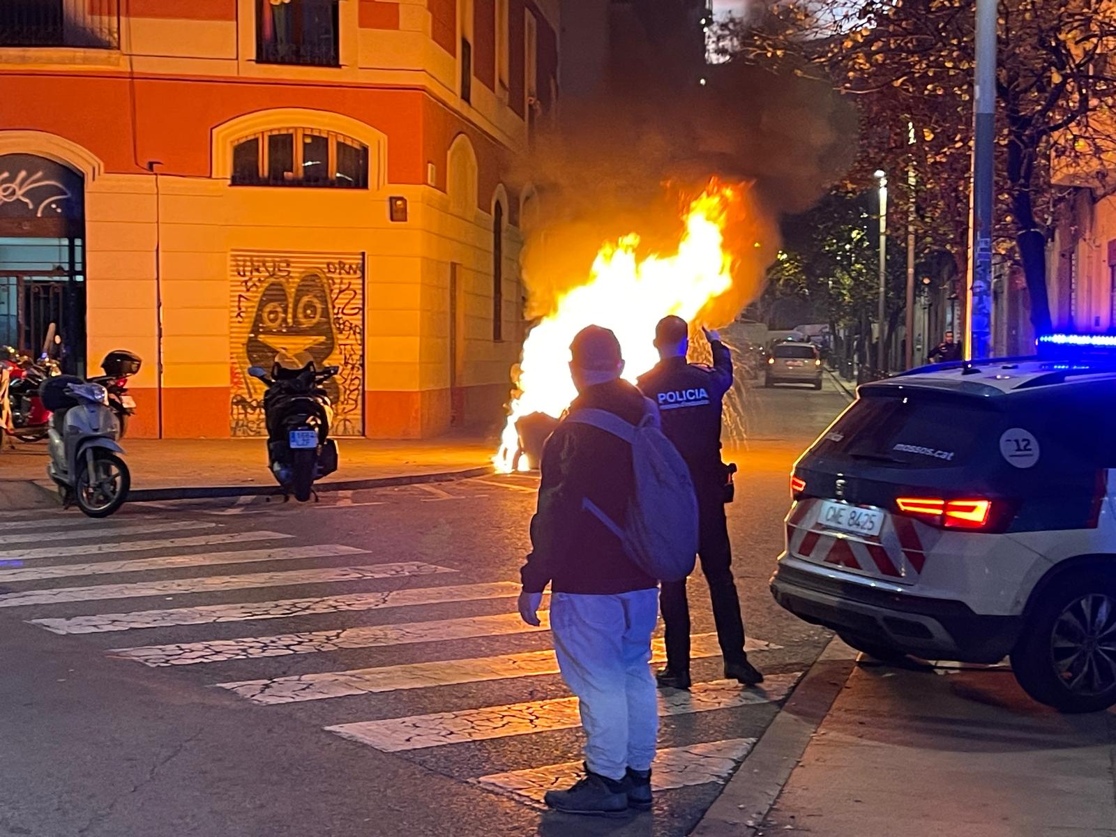 Una patrulla dels Mossos al Raval mentre crema un contenidor, aquesta tarda / Quico Sallés