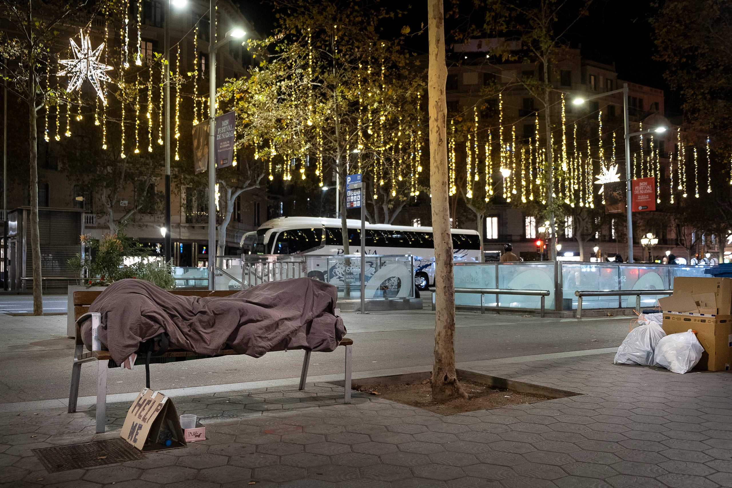 Una persona sense llar dorm a un banc del passeig de Gràcia durant el Nadal.
27.12.2024, Barcelona
foto: Jordi Play