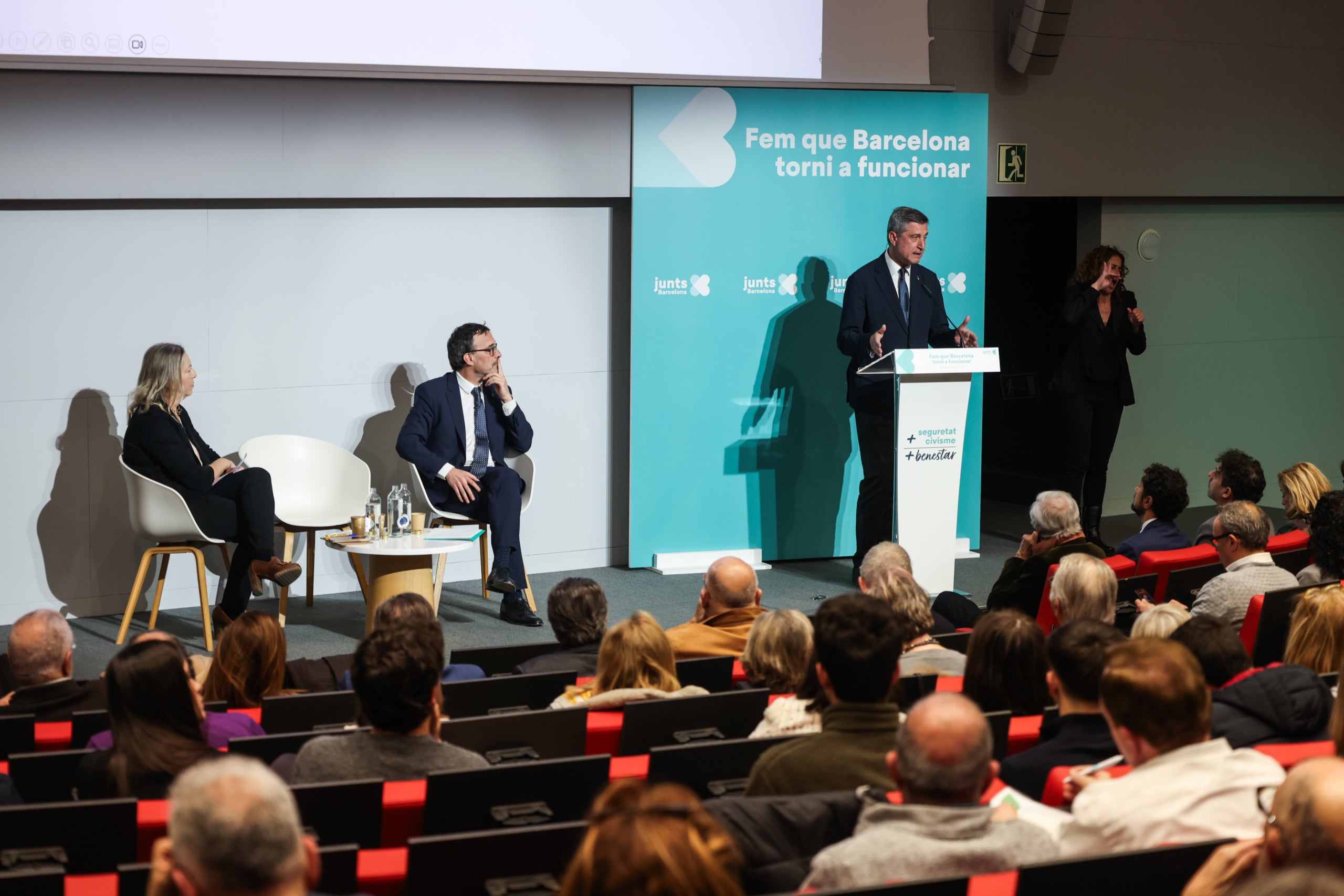 El president de Junts a l'Ajuntament Jordi Martí Galbis, i els regidors Neus Munté i Josep Rius asseguts, a l'acte a l'UPF / Junts