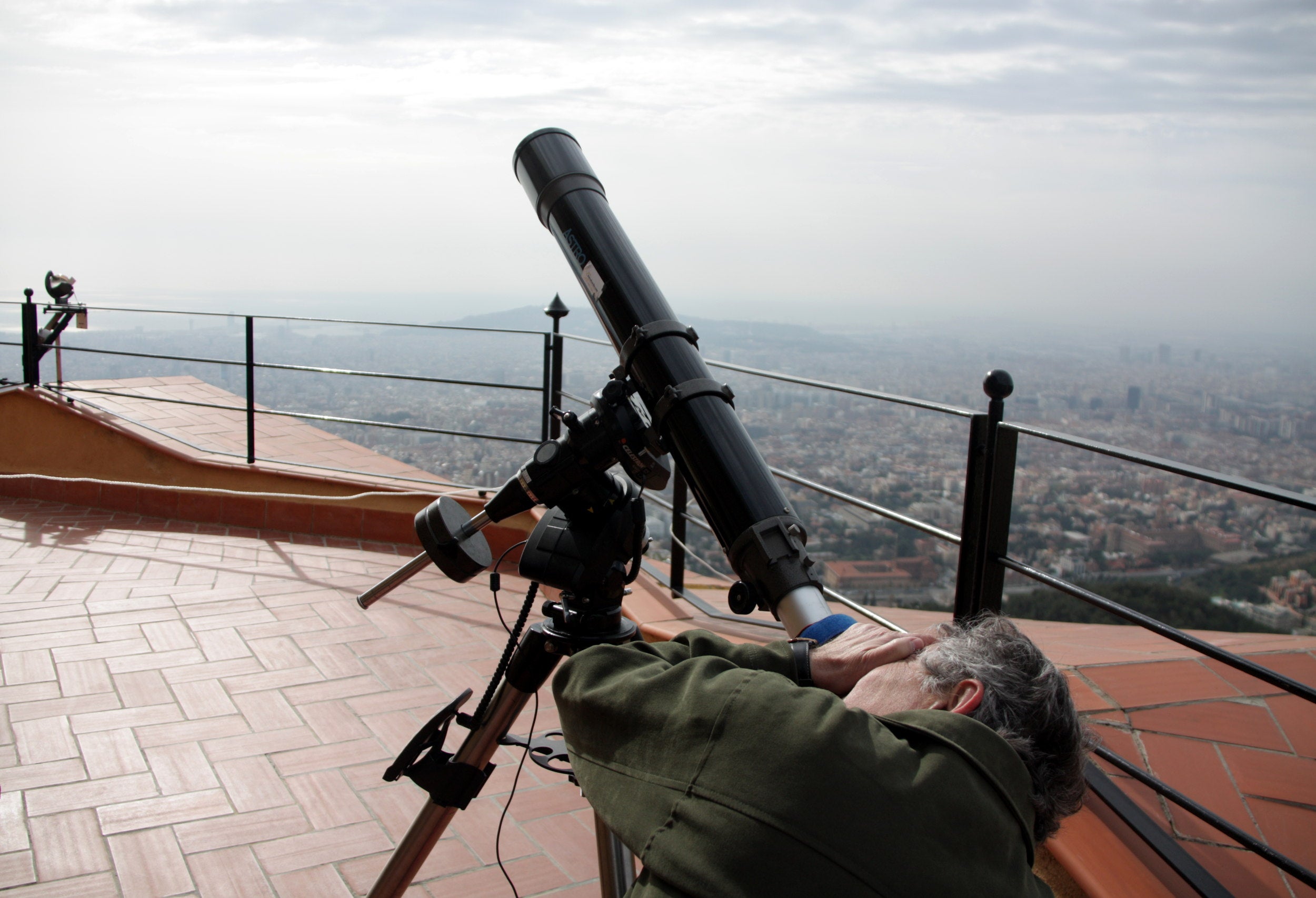 Un aficionado intenta observar el eclipse solar desde el Observatorio Fabra con un telescopio, a pesar de la capa de nubes sobre el cielo de Barcelona / ACN