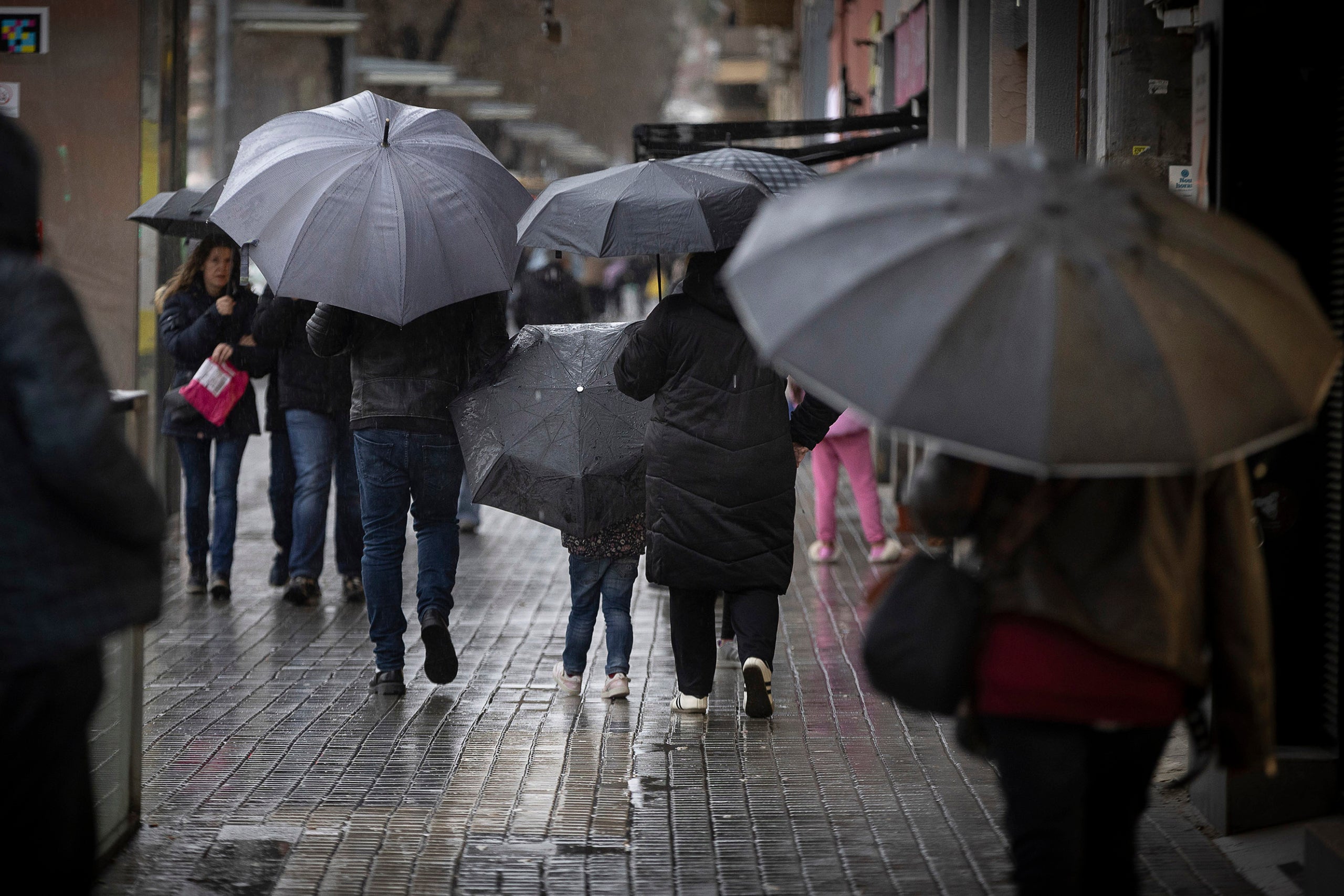 Diverses persones caminen amb paraigua sota la pluja a Barcelona / Jordi Play