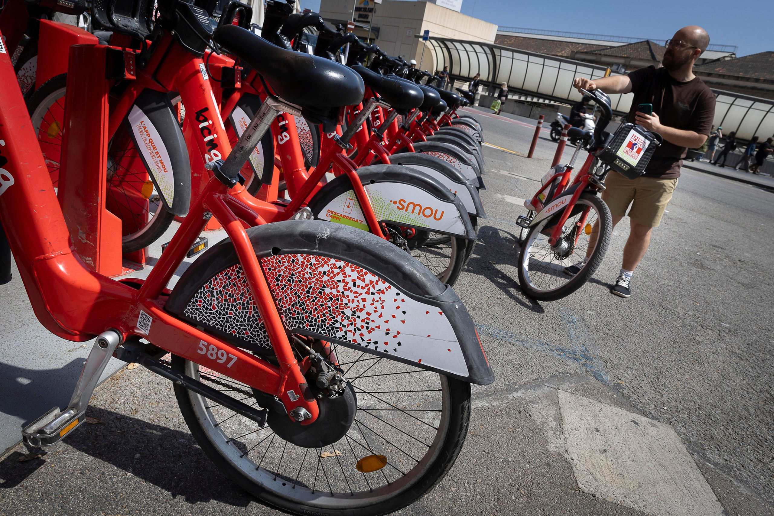 Un usuari agafa una bicicleta del Bicing / Jordi Play