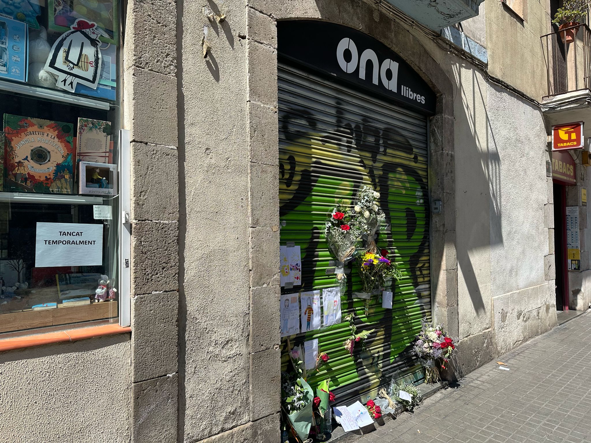 Flors i dibuixos a la persiana de la llibreria Ona de Gràcia TOT BARCELONA