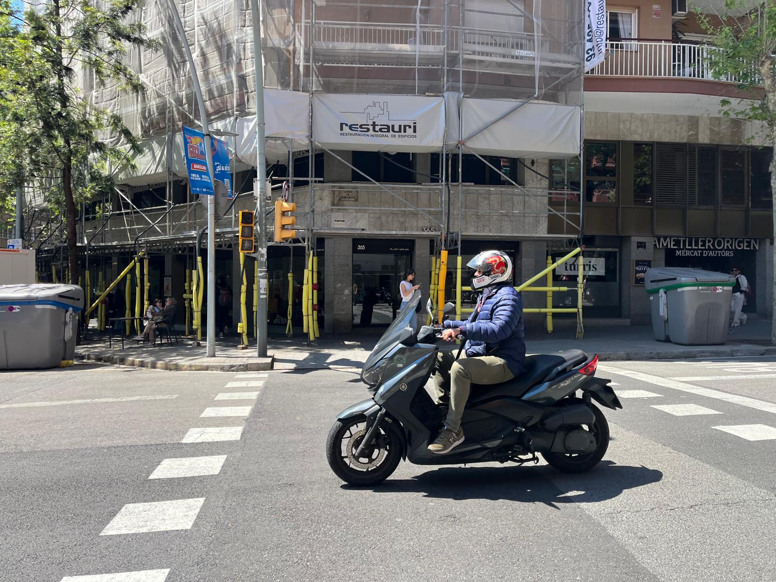 Imatge d'un motorista esperant enmig d'un pas de zebra / J.C.