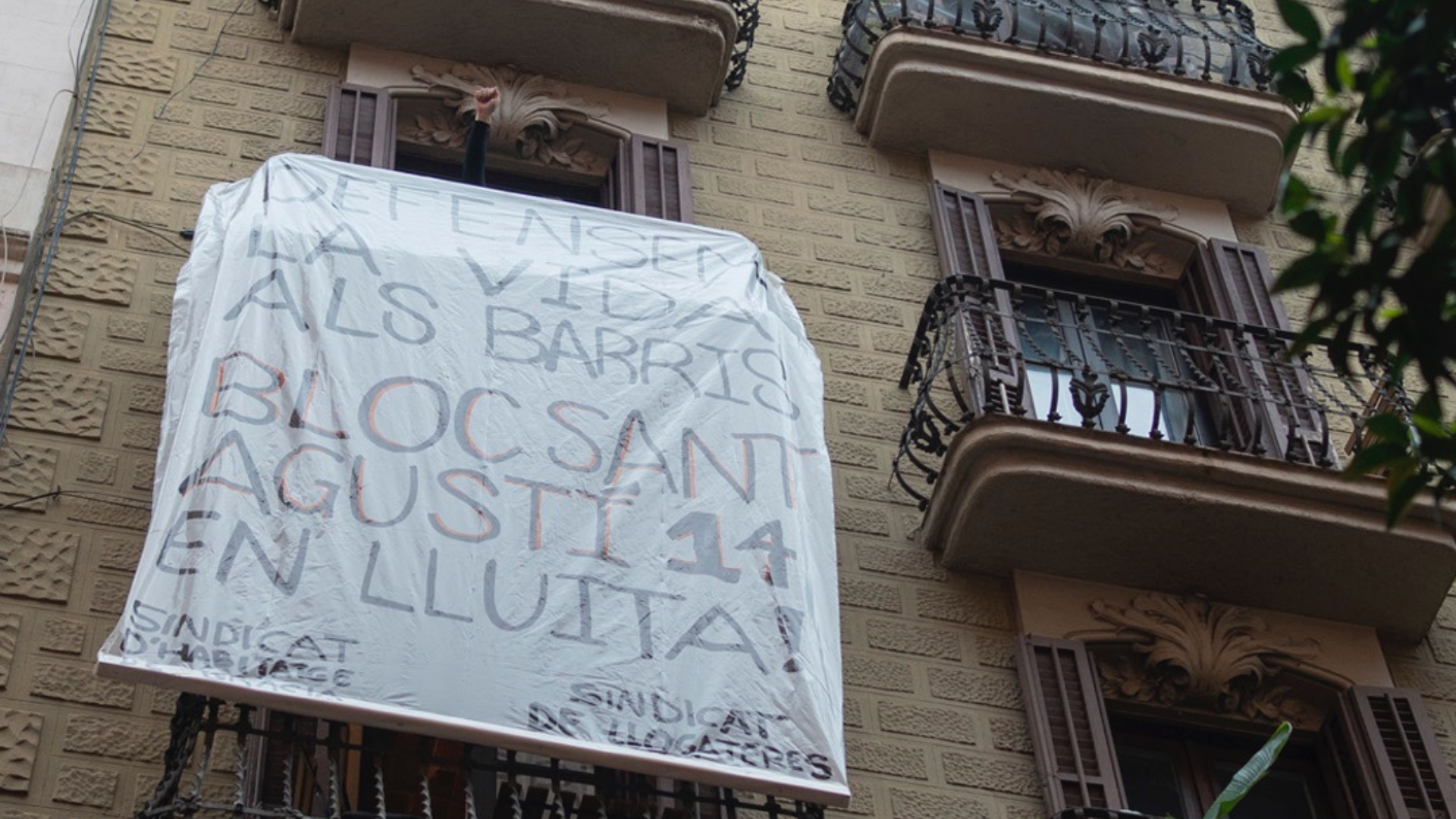 Pancartes en un dels balcons del bloc del número 14 del carrer de Sant Agustí de Gràcia, convertit en un coliving / Sindicat de Llogateres
