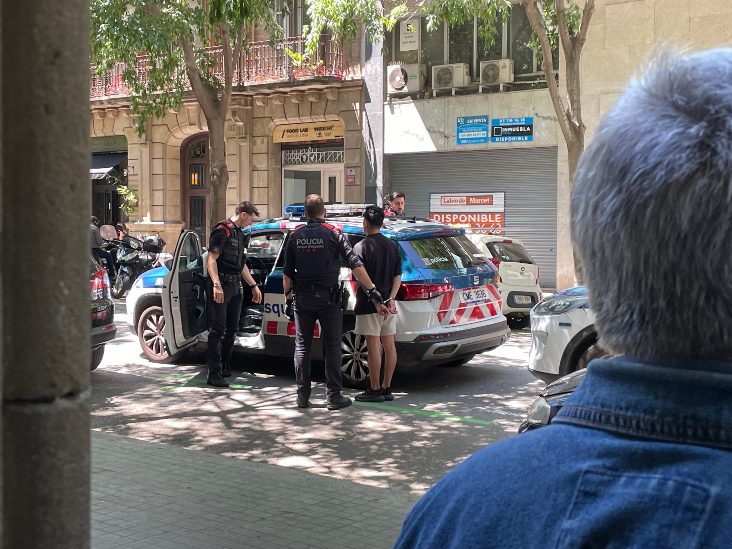 Moment de la sortida dels dos detinguts durant l'operatiu per desmantellar la gran plantació de marihuana del carrer de Tamarit / A.R.