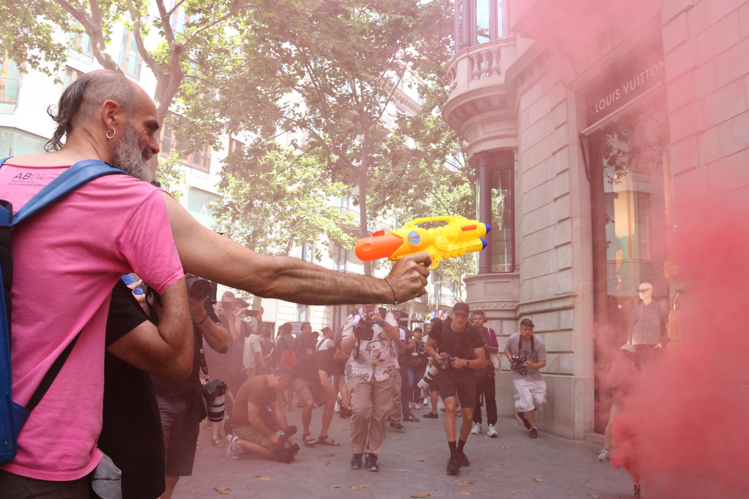 Un manifestante lanzando agua con una pistola de juguete a la tienda Louis Vuitton del paseo de Gràcia / ACN
