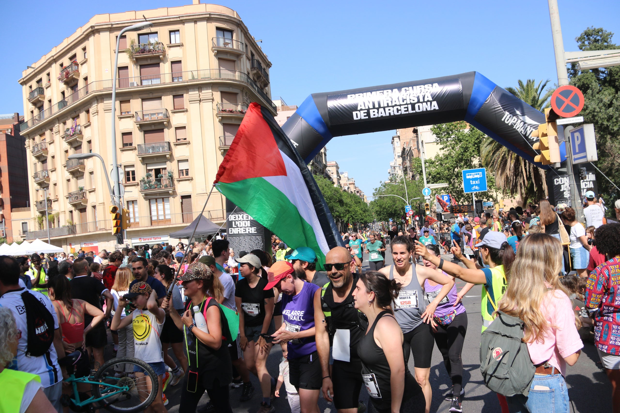 Meta de la cursa antiracista del Top Manta amb banderes palestines i cartells contra el racisme / ACN
