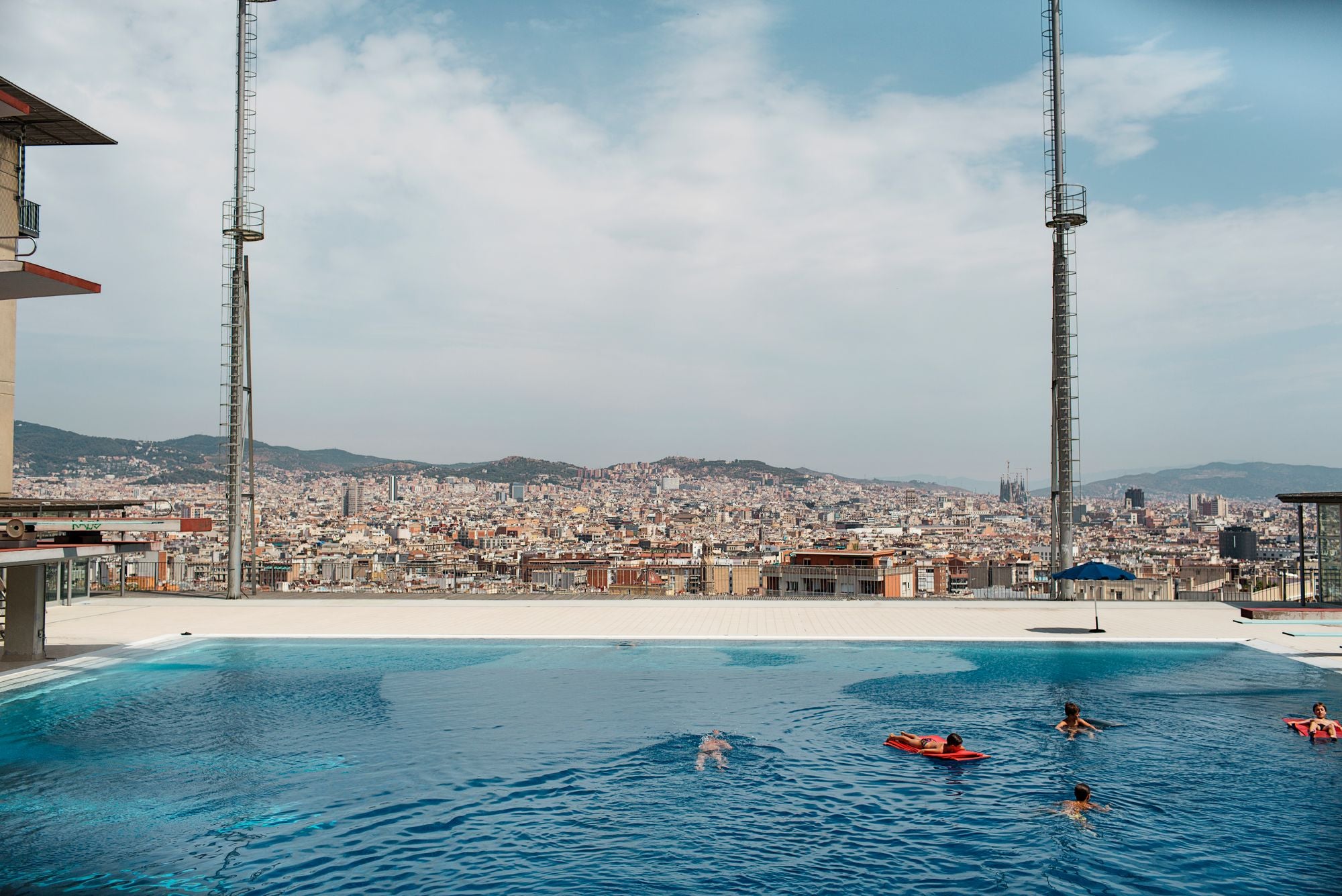 Piscinas Municipales de Montjuïc. Niños nadando y tumbados en colchones inflables dentro de la piscina | Paola de Grenet / Ayuntamiento