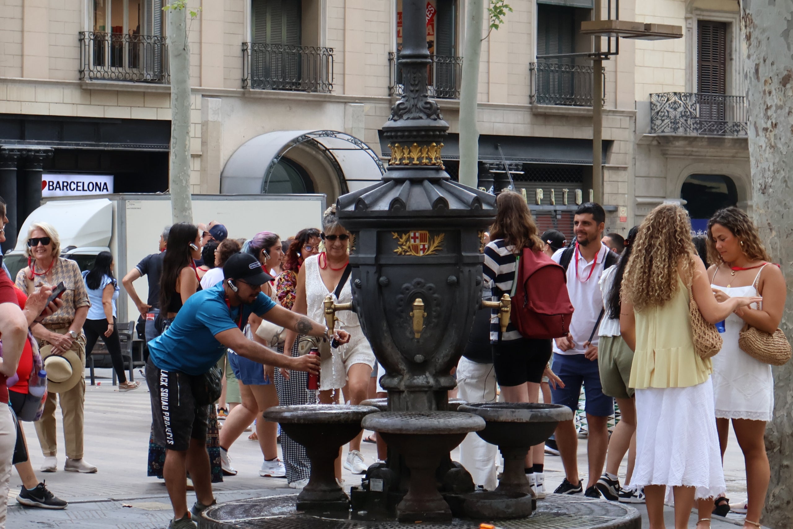 Calor. Un home omple la seva ampolla d’aigua en plena onada de calor davant de diversos turistes. / Marta Cardenal