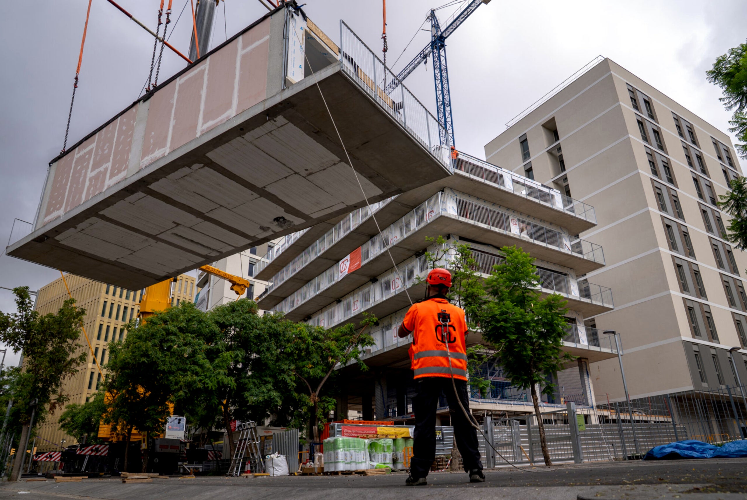 Una grua aixeca un dels blocs prefabricats per construir un edifici de pisos a la Bordeta. | Ajuntament de Barcelona