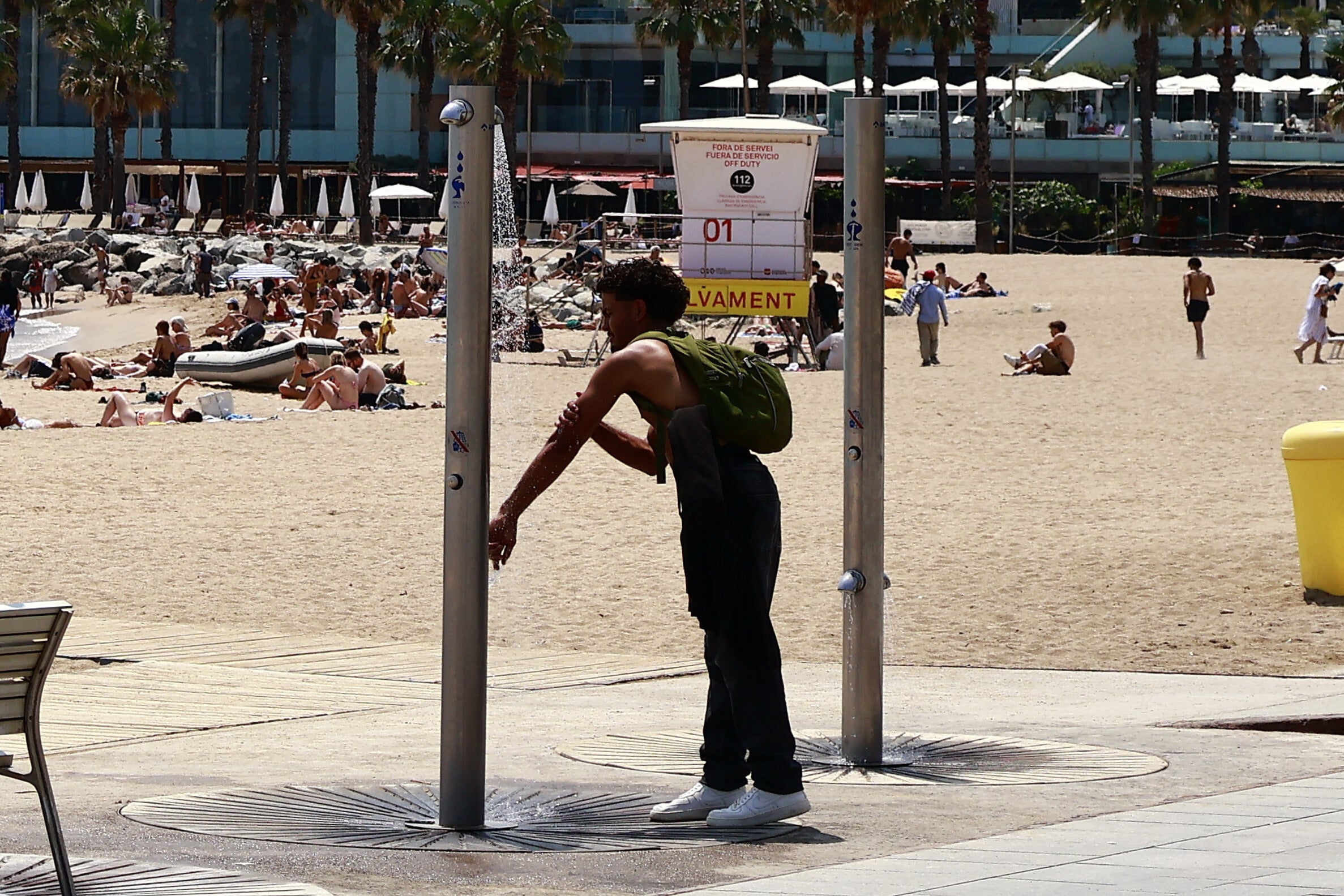 Un noi aprofita per refrescar-se a les dutxes de la platja de la Barceloneta degut a les altes temperatures, l'estiu passat / Marta Cardenal 