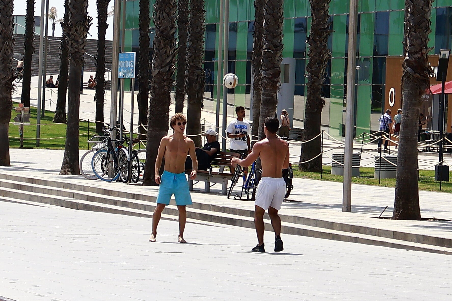 Esport i calor. Dos nois juguen a pilota a la platja de la Barceloneta. / Marta Cardenal 