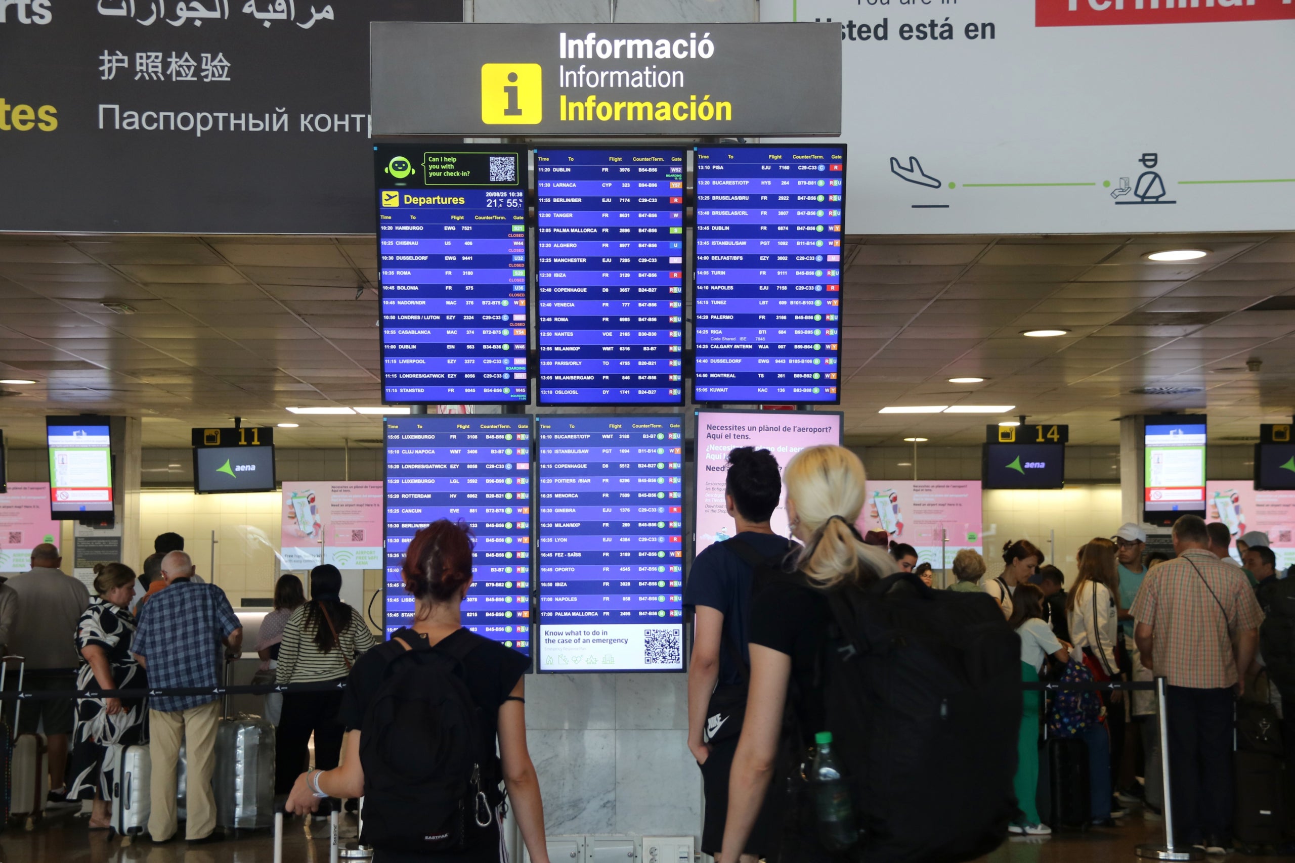 Passatgers miren la pantalla de sortides al Prat / ACN