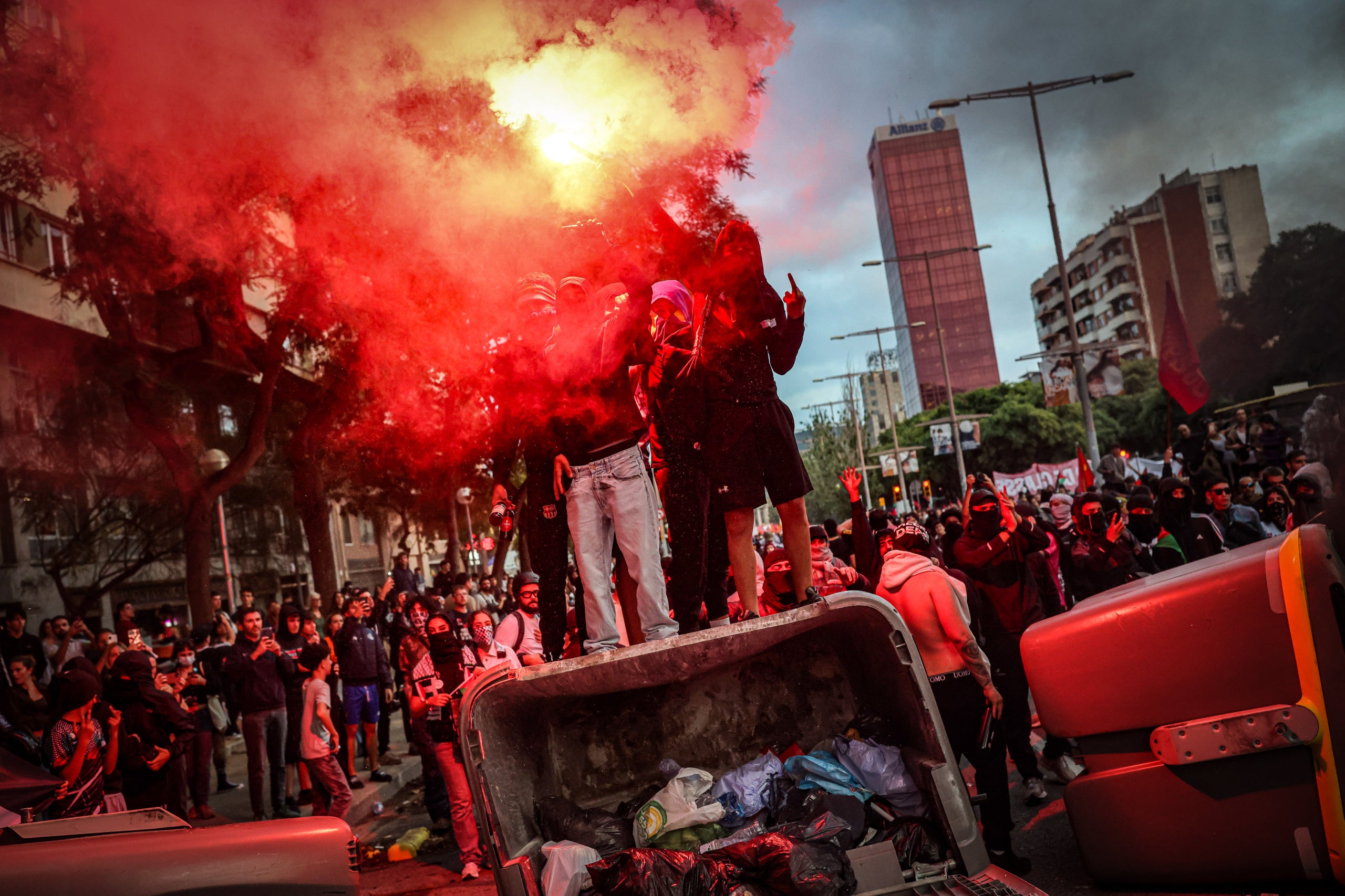 Diverses persones amb un objecte incendiat sobre un contenidor durant una manifestació a favor de Palestina a Barcelona / ACN / Jordi Borràs