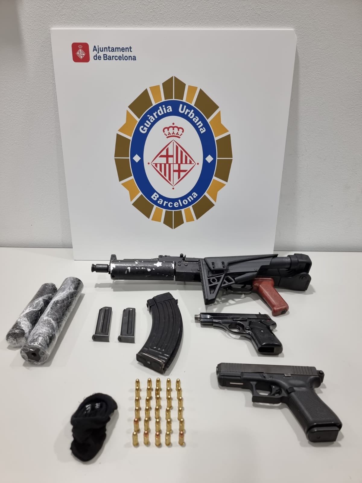 Las armas interceptadas por la Guàrdia Urbana, con el subfusil y los silenciadores / Cedida al TOT Barcelona
