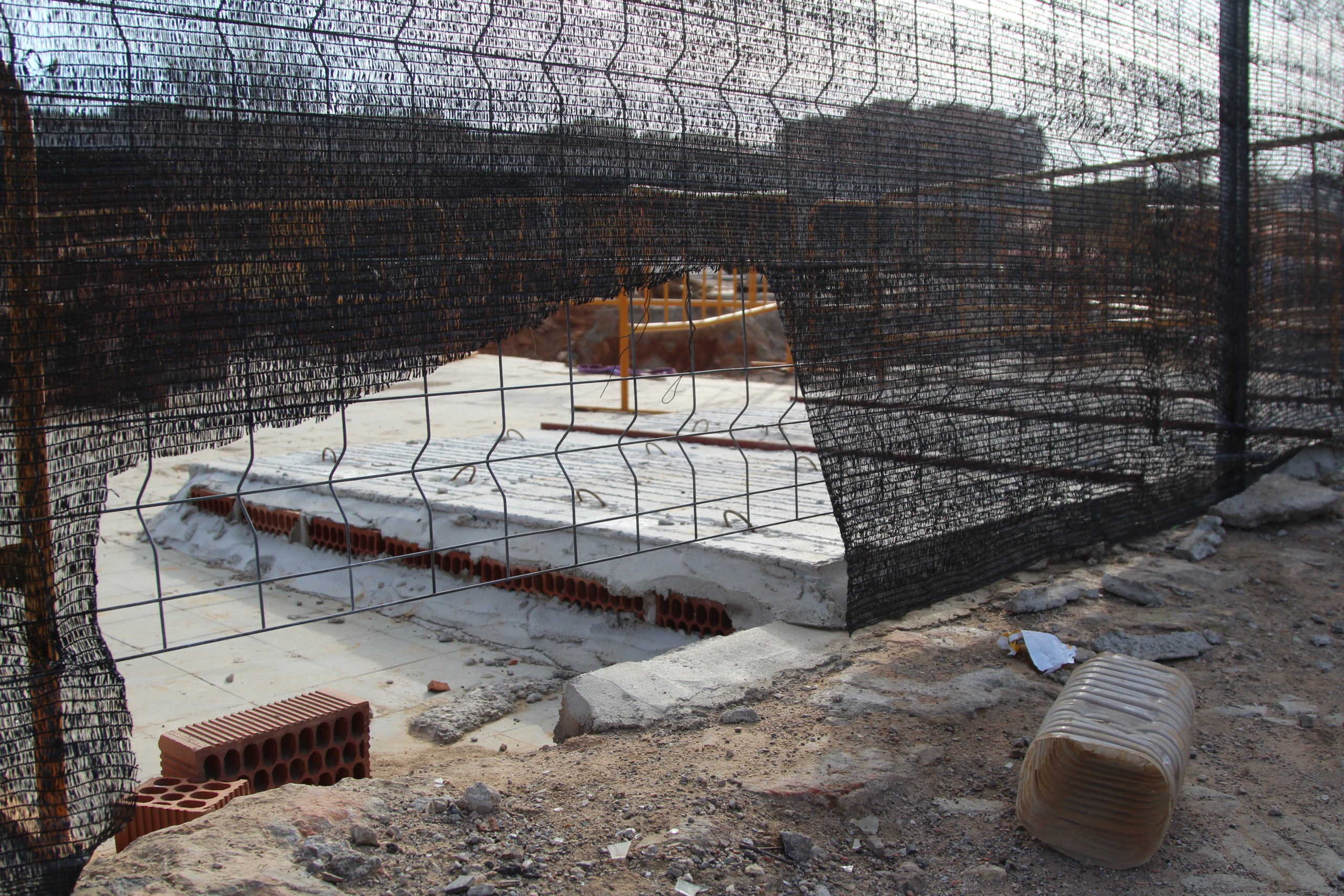 El refugi de l'antiga estació de mercaderies de la Sagrera amb una llosa col·locada a sobre i les obres al fons / A.R.