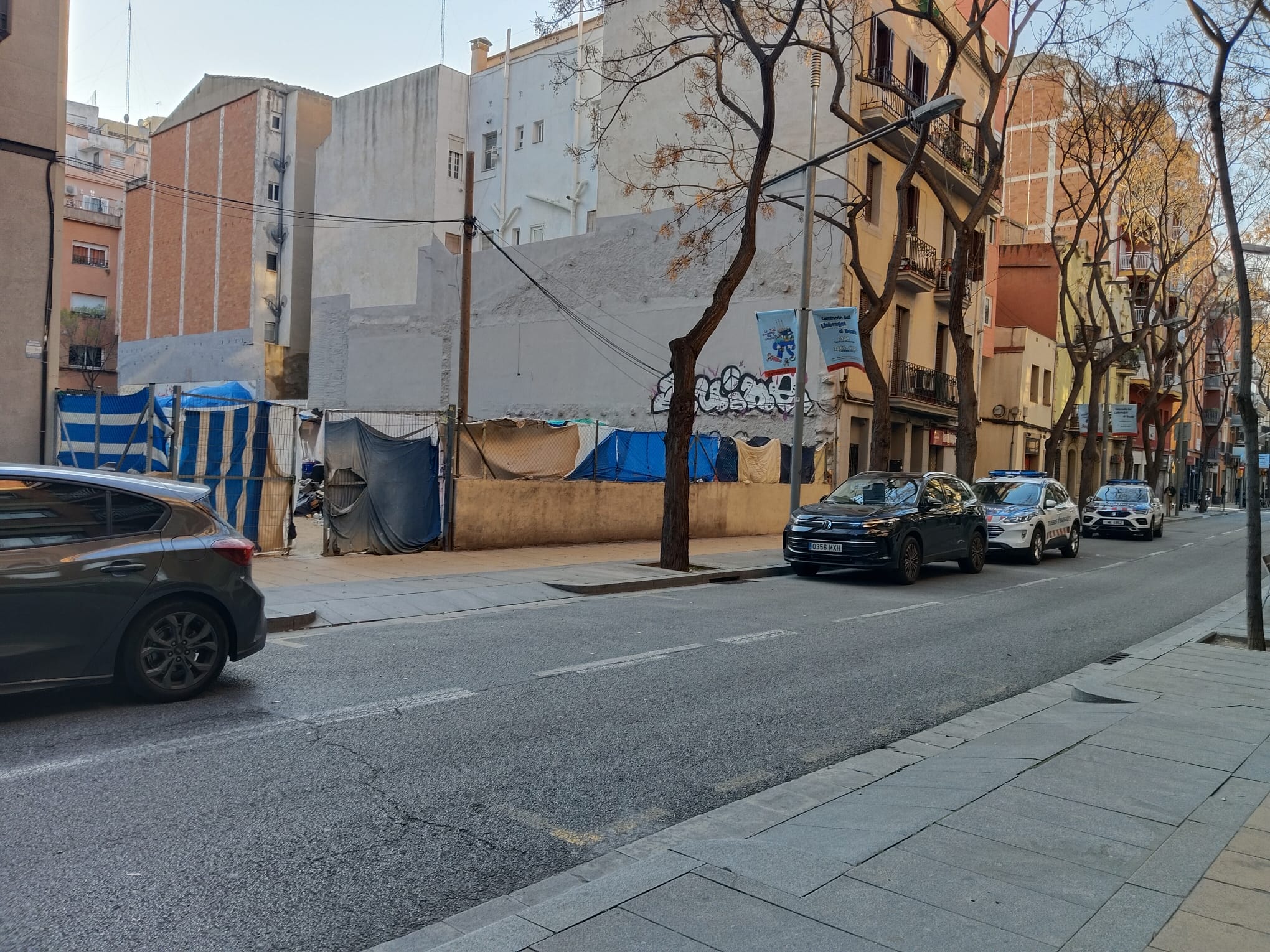 Dos cotxes dels Mossos en el solar del carrer de Sant Andreu de Palomar on va morir una noia de 19 anys, aquest diumenge / Cedida al TOT Barcelona