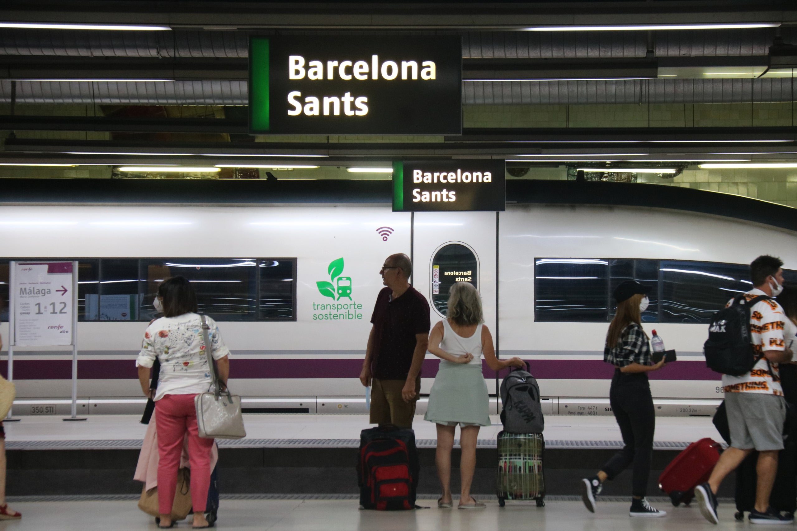 Passatgers a les andanes de l'estació de Sants de Barcelona, amb un AVE de fons 

| Marta Vidal (ACN)