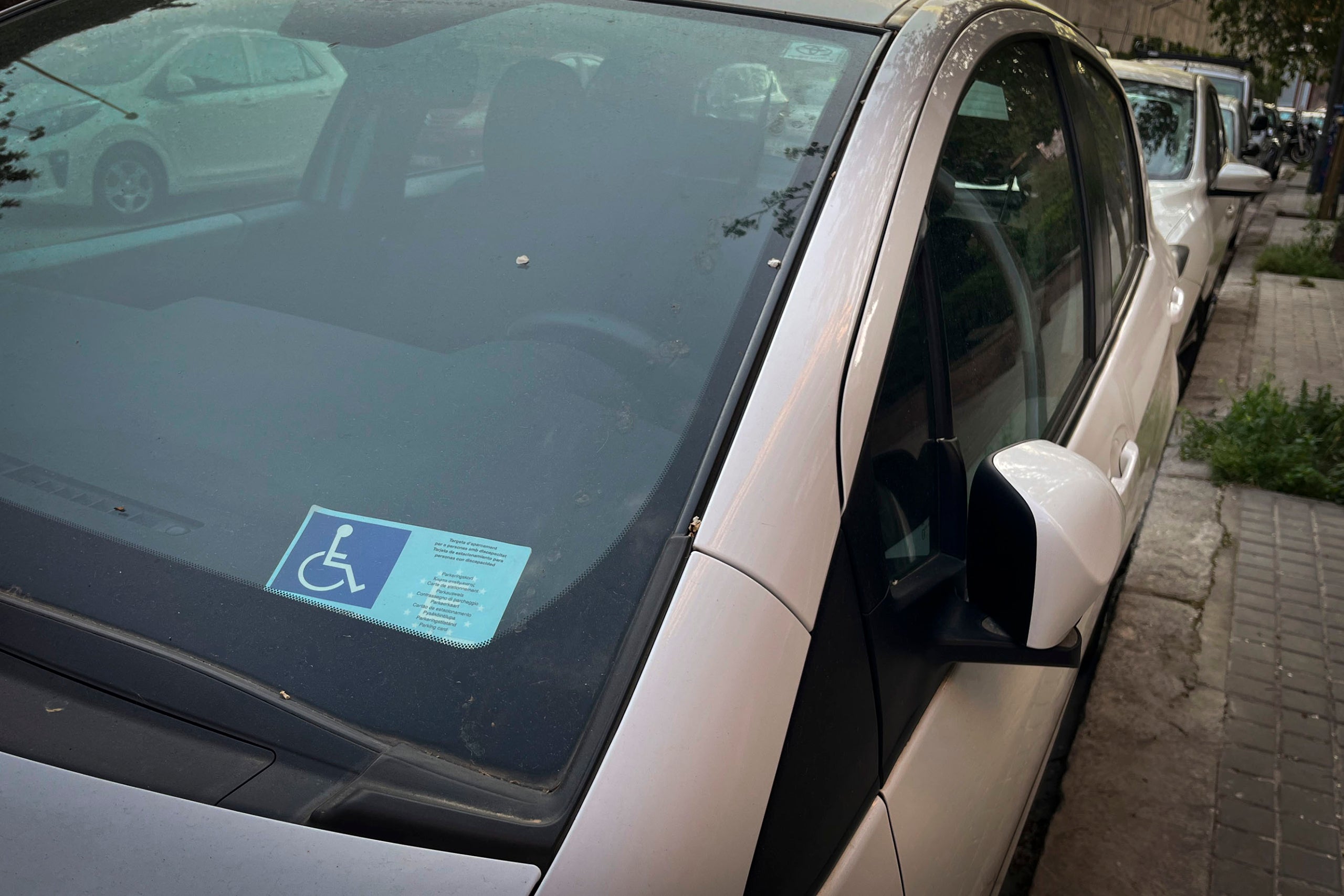 Una targeta d'estacionament per a persones amb mobilitat reduïda en un vehicle a Barcelona / Jordi Play per a totbarcelona.cat