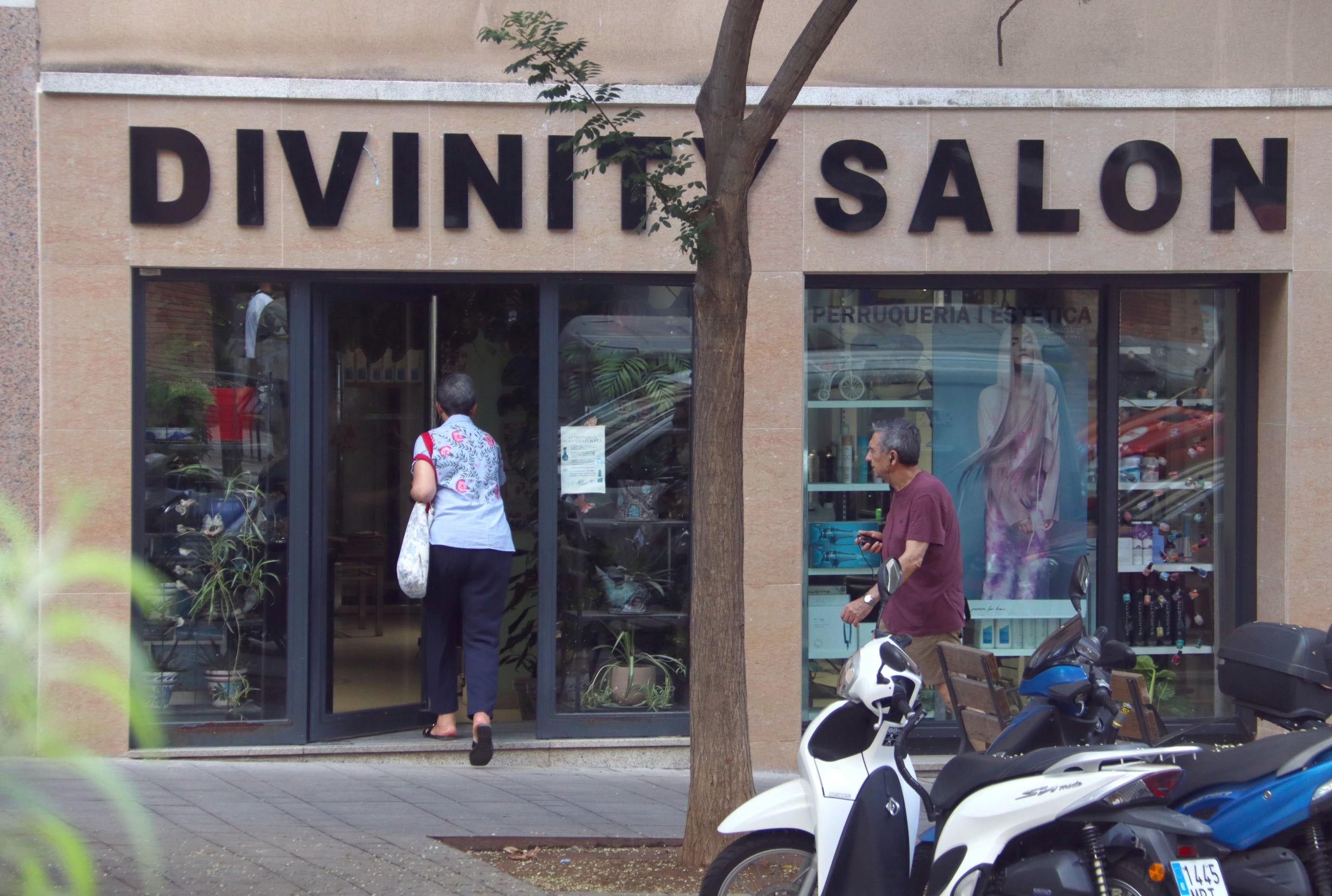 Una clienta entra en un centre d'estètica retolat en anglès, al districte de Gràcia / ACN