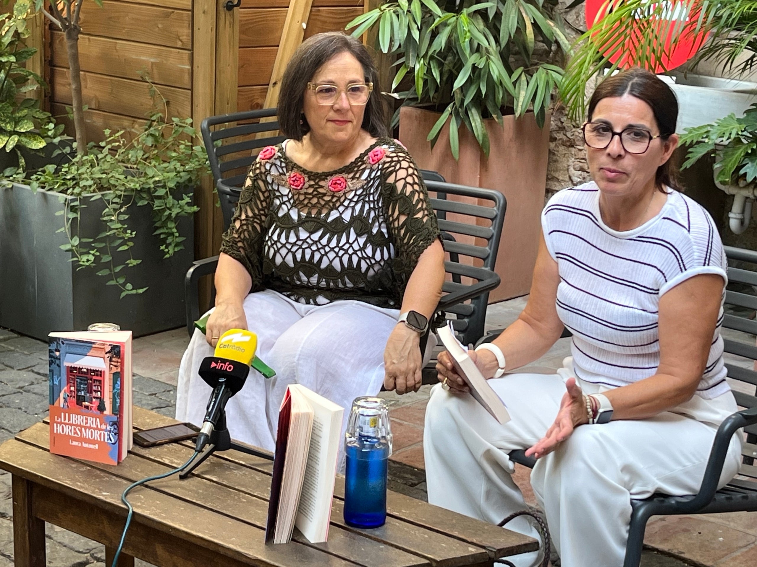 Laura Autonell, autora de 'La llibreria de les hores mortes' amb l'editora de Columna, Glòria Gasch, al pati de la cafeteria de La Central del Raval, durant la trobada amb la premsa / S.B.